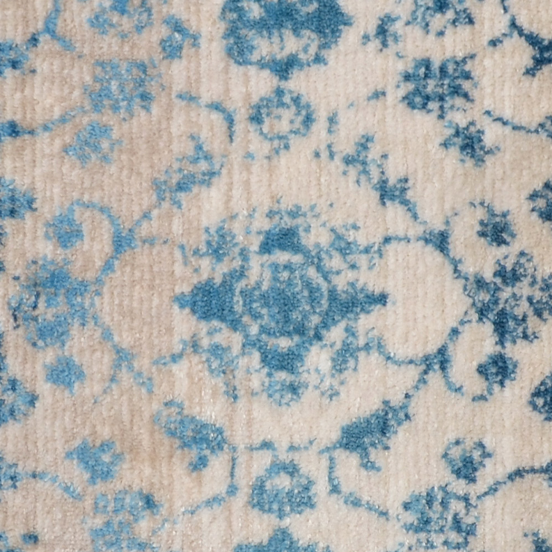 Detailed view of blue floral medallion design on cream rug ground.