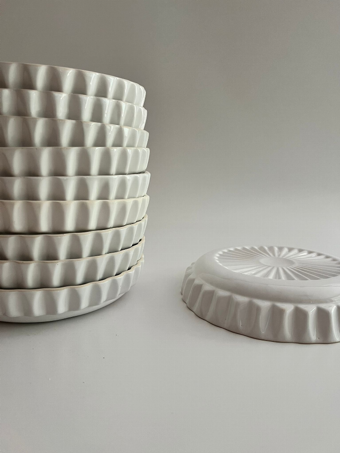 Handmade ceramic dinner plates stack, white ridged edges and embossed center