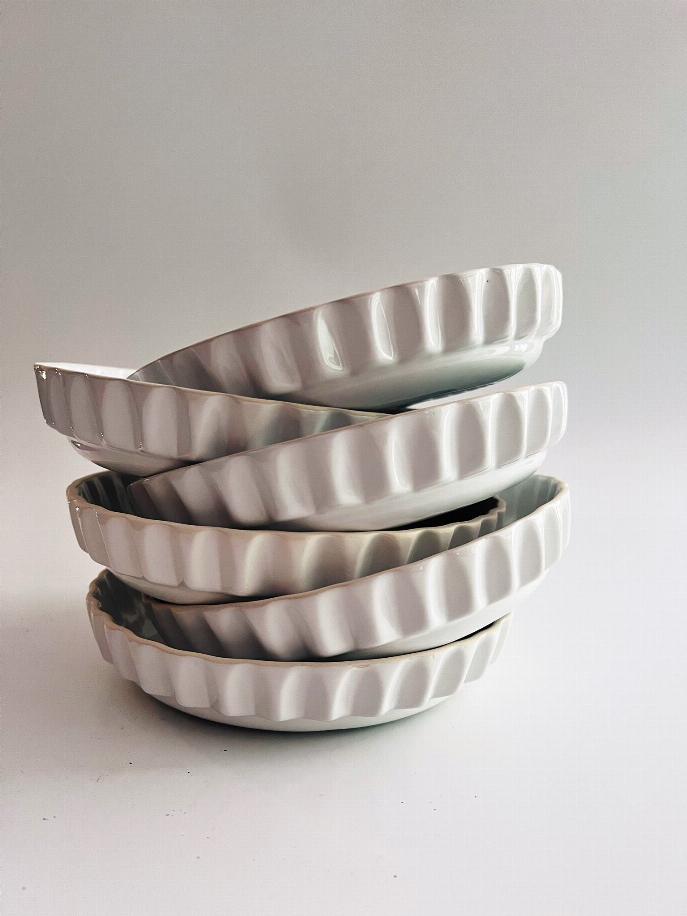 Handmade ceramic dinner plate stack, white with vertical ridged sides and embossed center