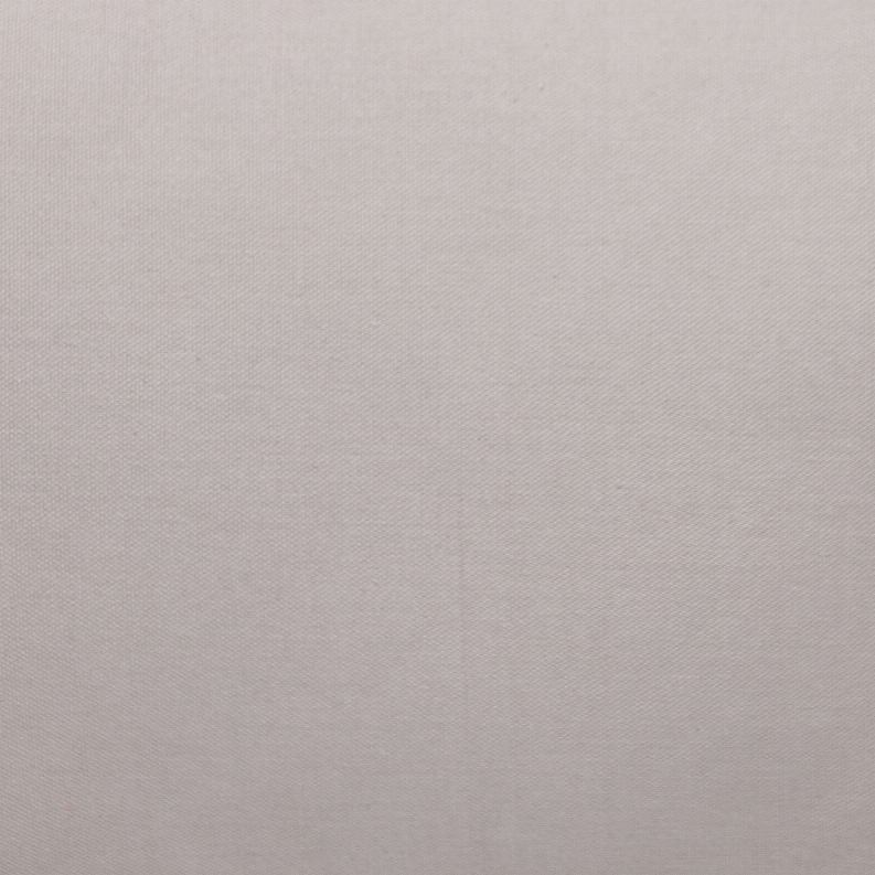 Natural solid pillow fabric close-up with visible woven texture and piping edge
