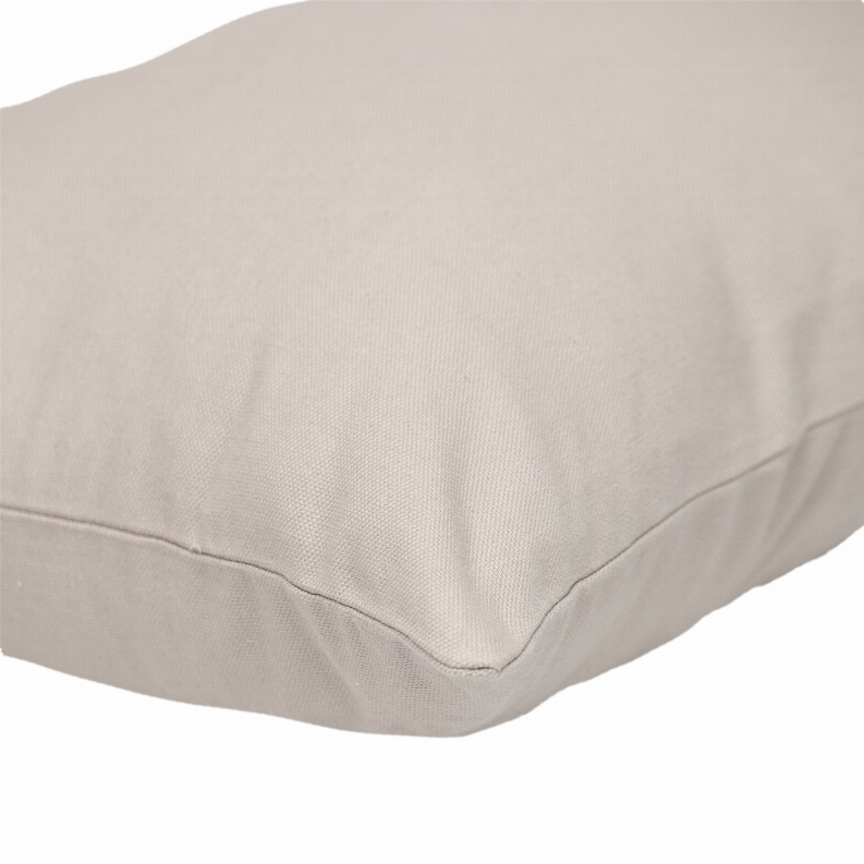 Natural solid pillow corner with stitched seam and smooth, woven fabric texture