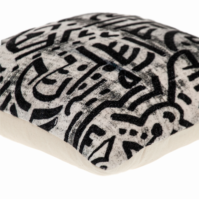 Cream throw pillow corner with black geometric abstract pattern
