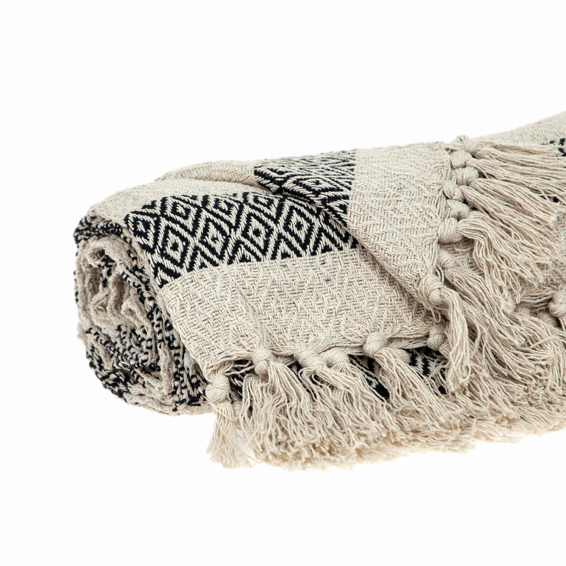 Beige woven throw featuring black diamond and zigzag pattern with tassel trim