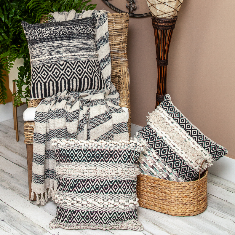 Beige and black patterned woven throw with tassel fringe, folded over a chair