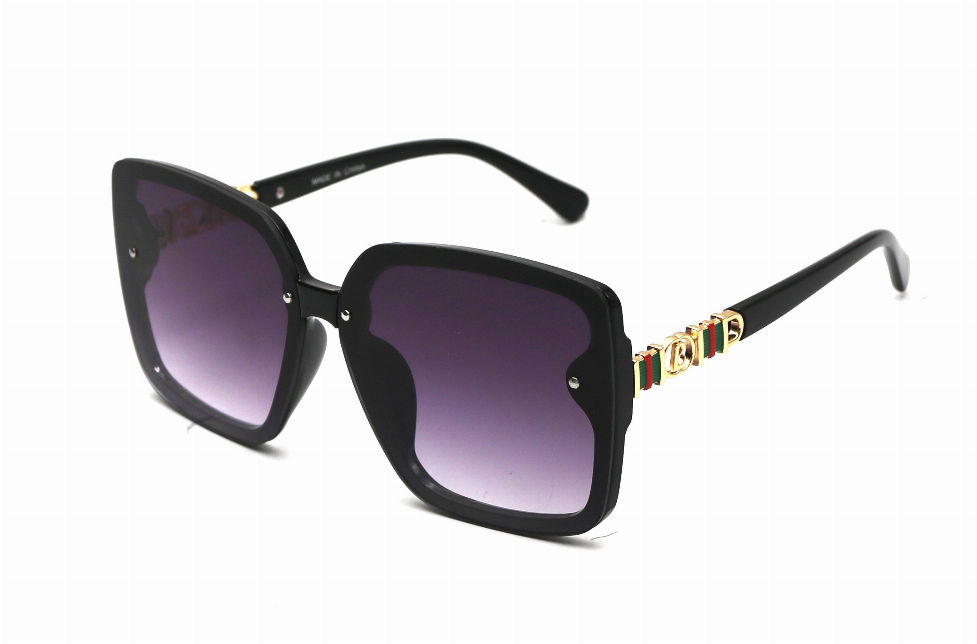 Black sunglasses with purple tinted lenses and decorative gold-toned temple detail