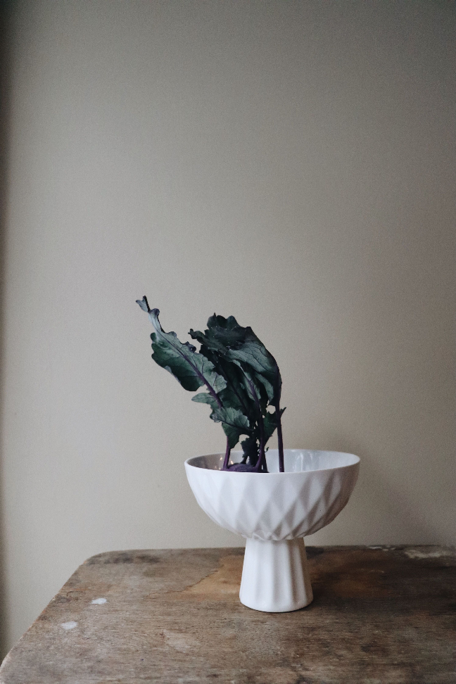 White ceramic footed serving bowl with diamond-texture sides and pedestal base
