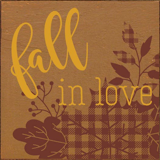 Plaid wood sign with cursive text "Fall in love" and autumn leaves graphic