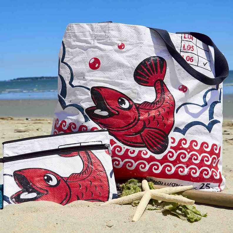 White double-zip case with red fish print, blue wave accents, and side strap