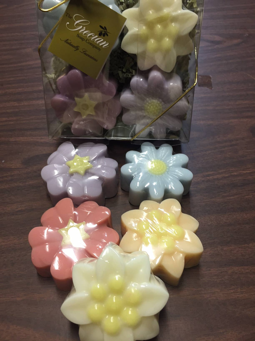 Assorted flower-shaped soap bars in pink, blue, purple, and yellow tones