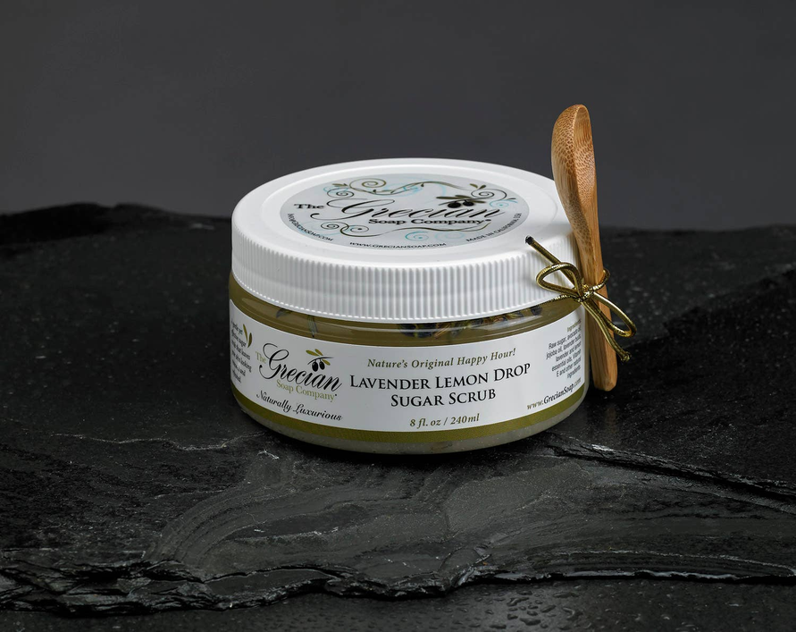 Lavender body scrub in white jar with ribbed lid and gold bow detail