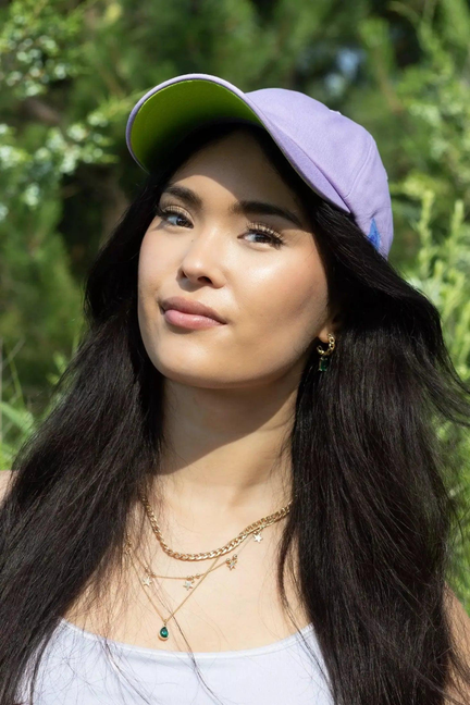Lavender baseball cap with green underside and small embroidered logo