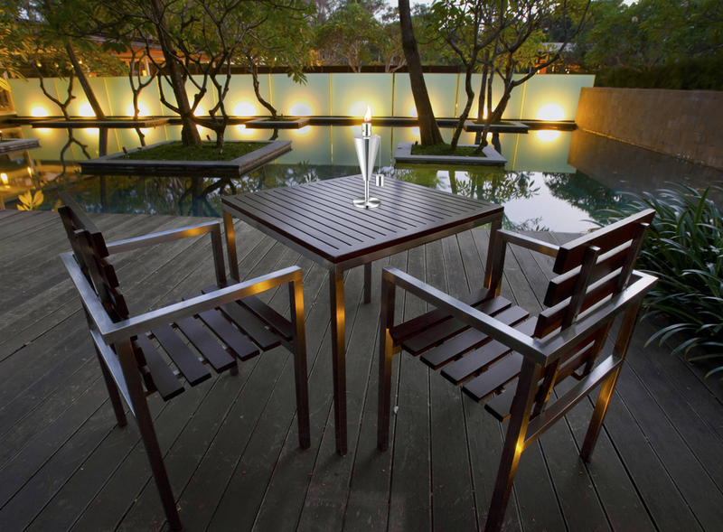 Outdoor tabletop garden torch standing on deck near an outdoor dining table