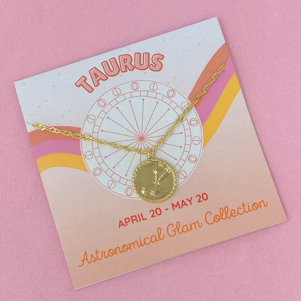 Gold-tone Taurus zodiac pendant necklace with chain on decorative gift card