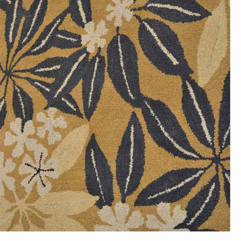 Close-up of floral area rug fabric: beige base with dark navy leaves and cream blossoms