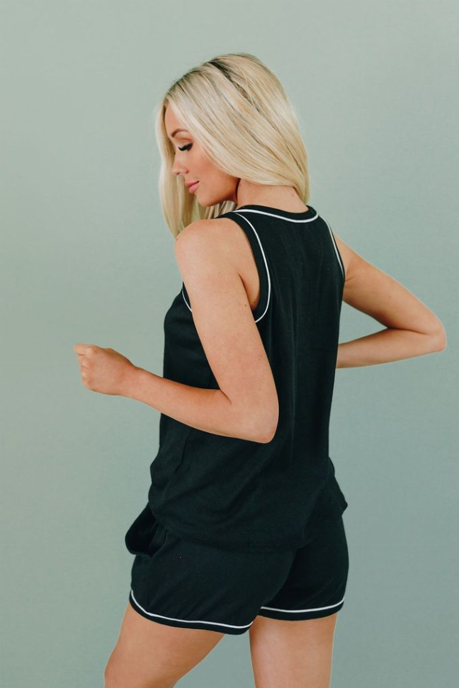 Black sleeveless lounge set side view with white piping trim and drawstring waist shorts