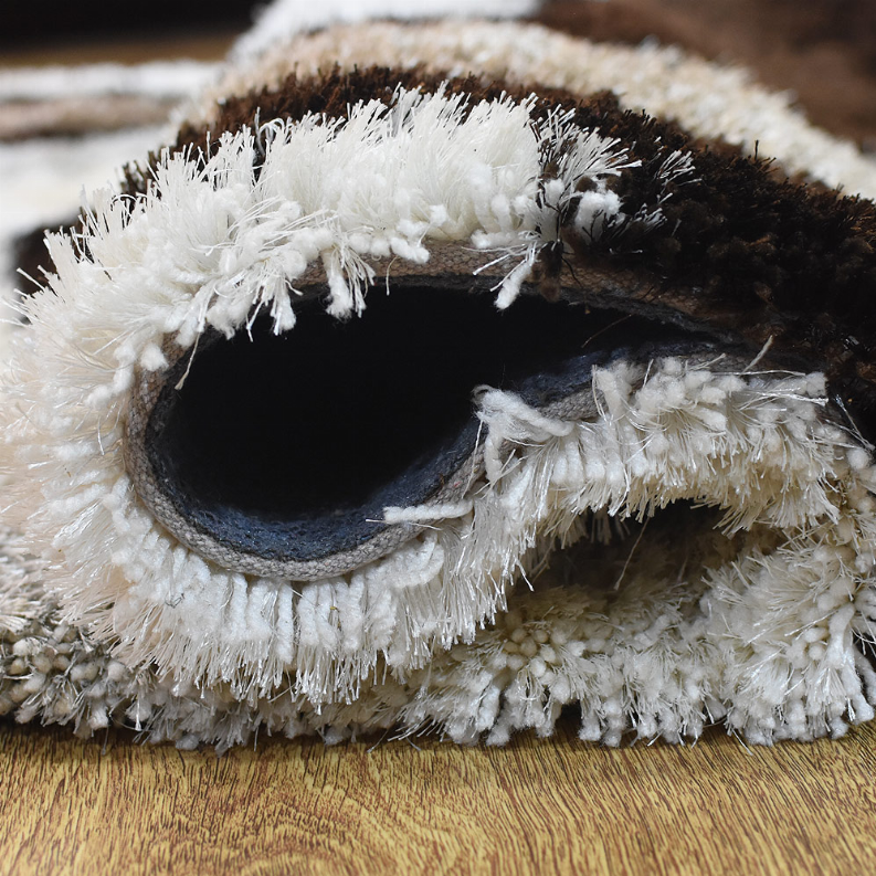 Shag rug edge detail with dense white fibers and dark backing layer