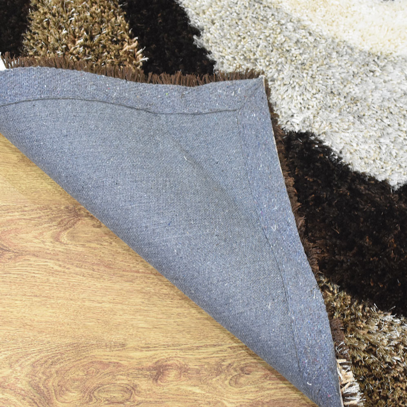 Shag rug corner with blue-gray backing and soft textured pile on multicolor edge