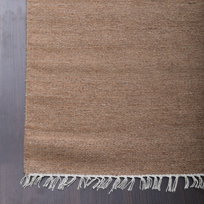 Tan wool flatweave kilim area rug with short fringe along one edge