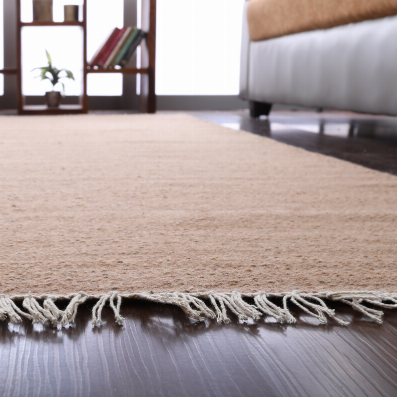 Tan wool flatweave kilim area rug with fringed border, laid flat
