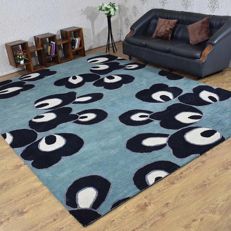 Floral blue area rug with dark navy and white flower shapes laid on wood floor