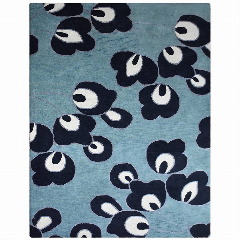 Floral area rug with blue base and scattered dark navy flowers outlined in white