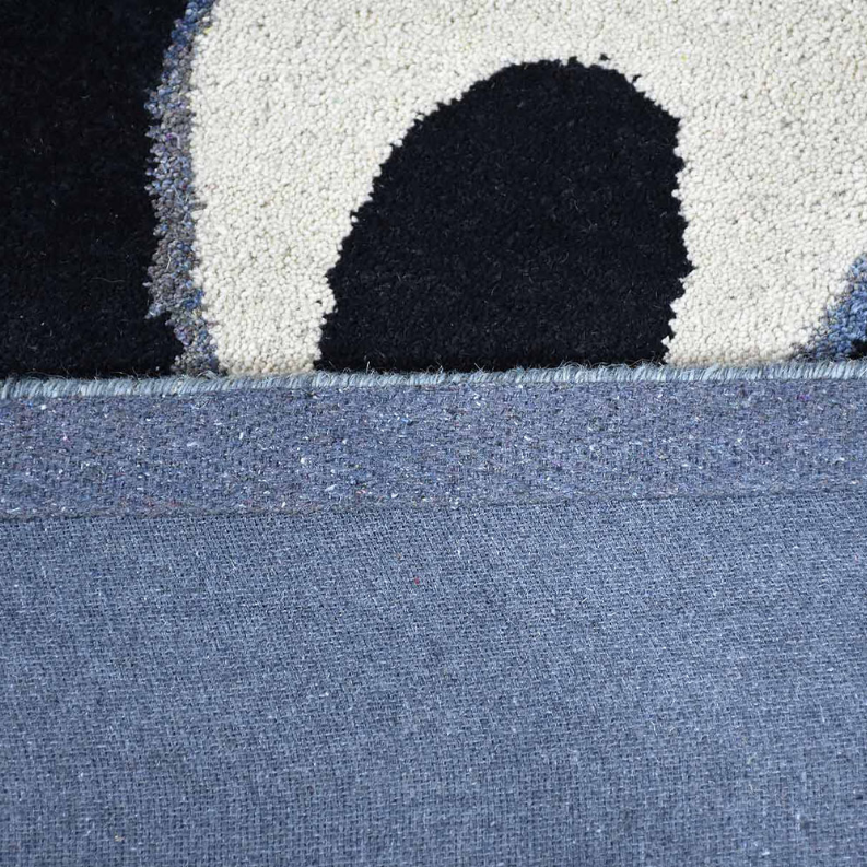 Close-up rug section showing dark navy oval motif on blue background