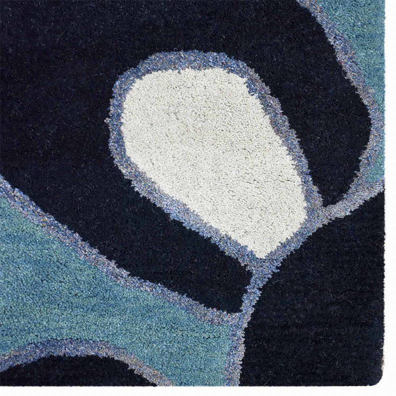Close-up of dark navy and blue floral rug section with pale outlined shapes