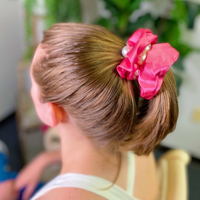 Pink satin scrunchie with ruffled bow and small pearl accent