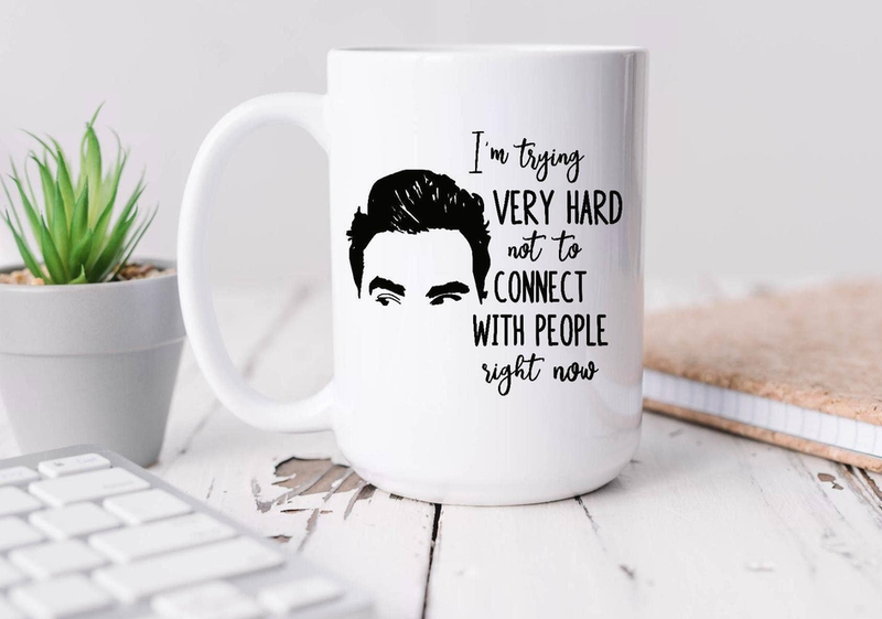 11oz white coffee mug with black connect-people text and portrait, on desk