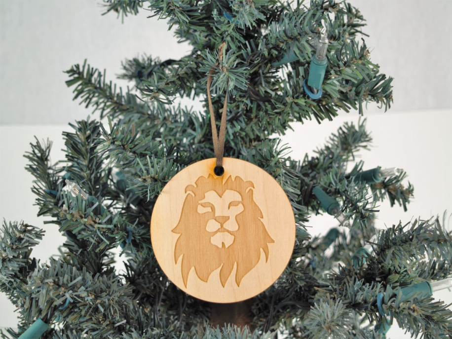 Unfinished lion wooden tree ornament with hanging loop on round disc
