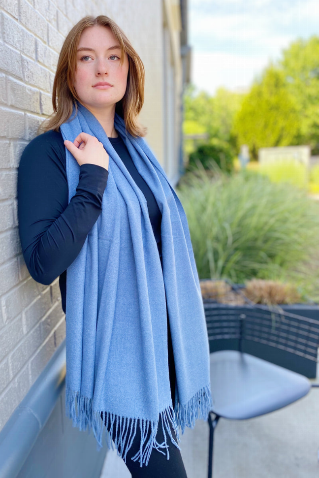 Light blue cashmere-blend scarf, fringed ends draped over shoulder