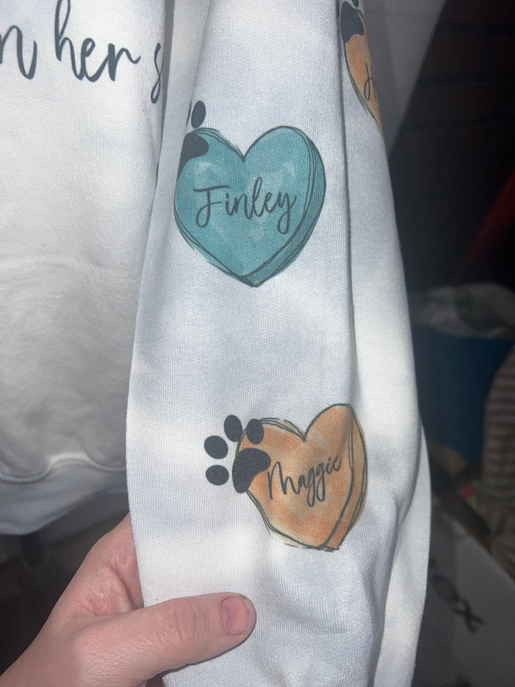 Light sweatshirt sleeve with heart and paw graphics labeled Finley and Myrja