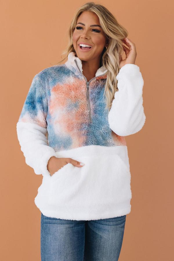 Tie-dye fuzzy pullover with half-zip and hood, blue/orange cloud pattern on chest