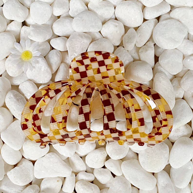 Maroon-and-gold check hair claw clip with glossy translucent base.