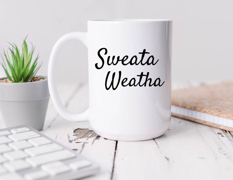 White coffee mug with 'Sweata Weatha' text, side handle view on tabletop