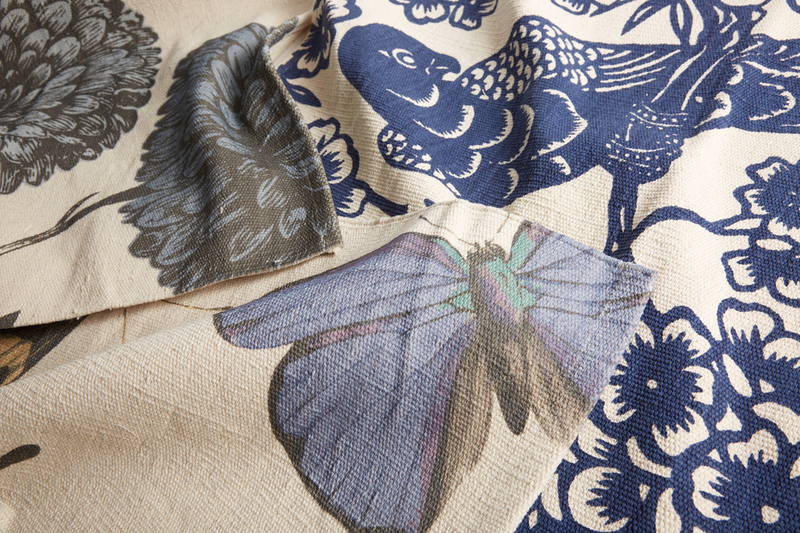 Metamorphosis floor mat with blue and gray floral-butterfly print, close-up corner