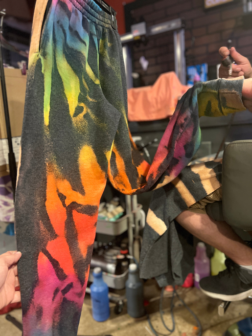 Rainbow burst tie-dye jogger pants with V-shaped seam and colorful swirl print