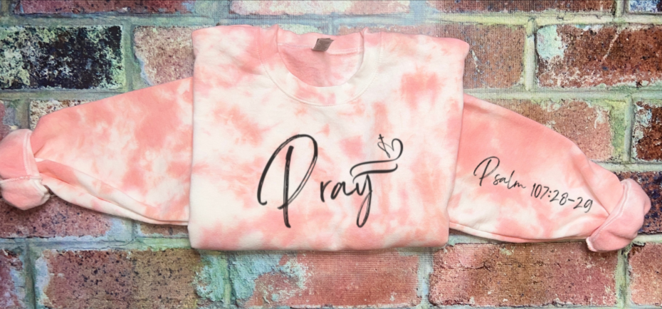 Coral tie-dye sweatshirt with Pray front graphic and Psalm 107:28-20 text
