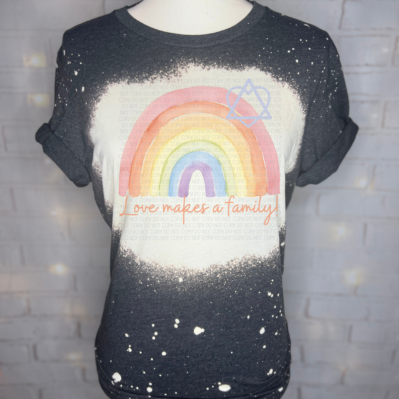 Dark graphic tee with bleached rainbow heart and 'Love makes a family' text