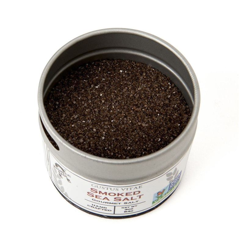 Round metal tin of gourmet sea salt with dark brown granules inside