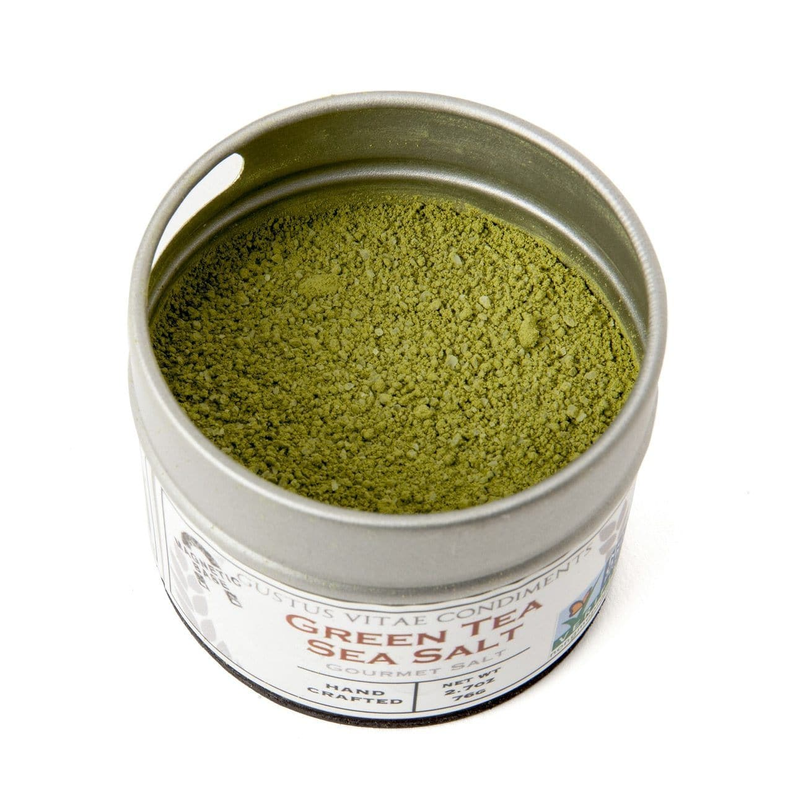 Round metal tin of gourmet sea salt with green granules inside