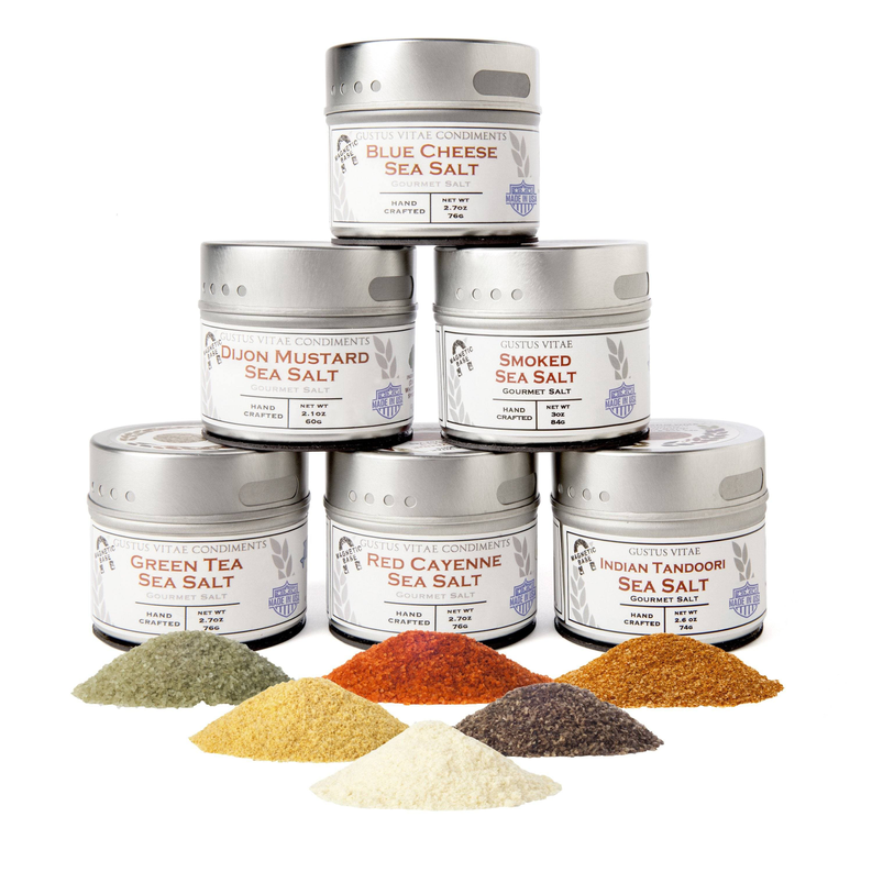 Stacked metal sea salt tins with mixed-color loose granules on a flat surface