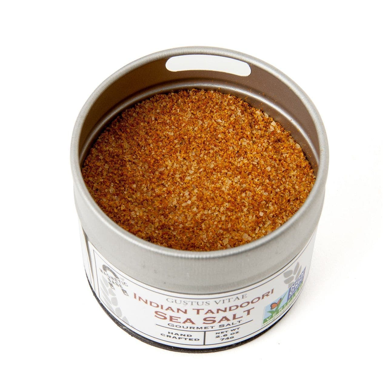 Round metal tin of gourmet sea salt with orange-brown granules inside