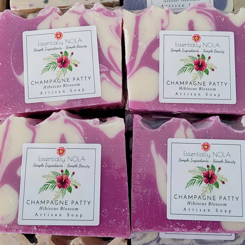Essentially NOLA hibiscus blossom soap bars with purple-and-cream swirls on labeled boxes