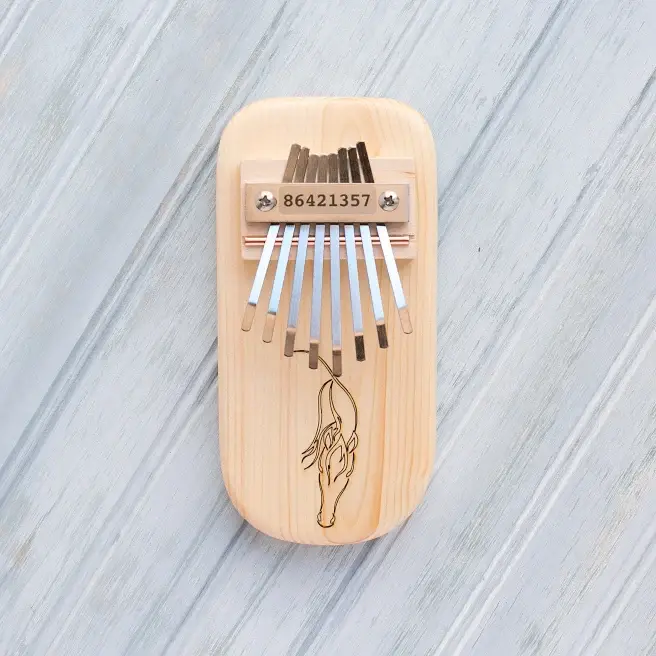 Wooden thumb piano with horse engraving, metal tines on front