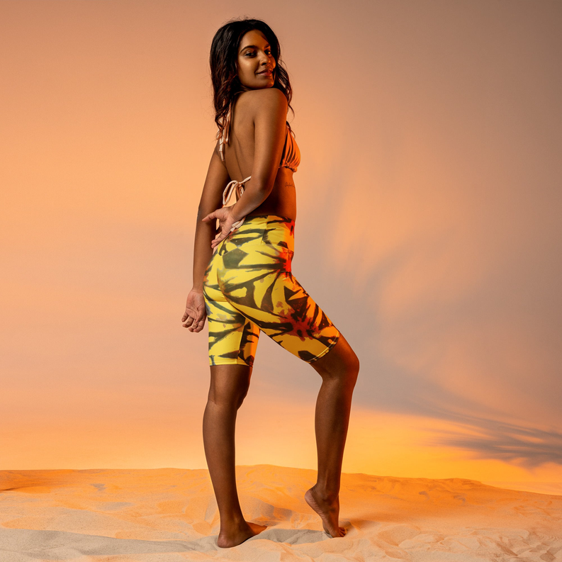 Yellow tie-dye biker shorts, mid-thigh length, side standing view