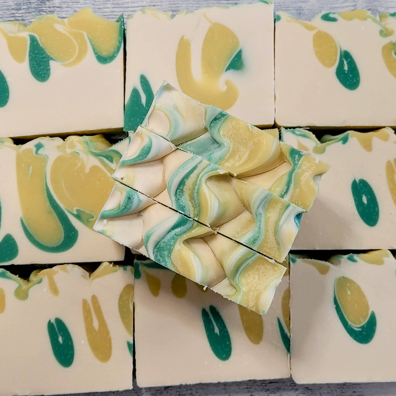 Swirled soap bars with teal and yellow patterns, stacked in a display