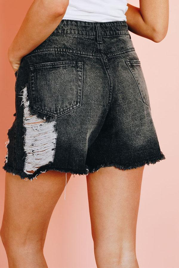 Black denim shorts with frayed hem and large distressed light panel at side