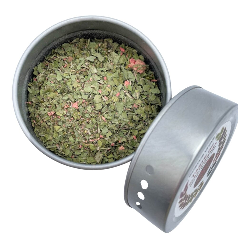Open silver seasoning tin with green herb blend inside and loose seasoning