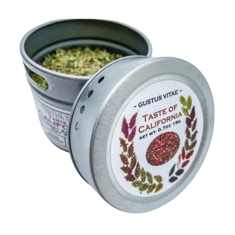 Silver seasoning tin open with green herb blend; lid tilted in front
